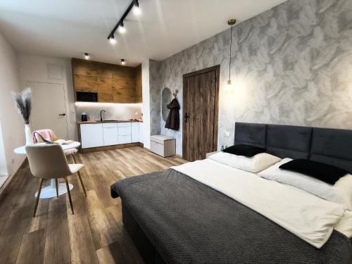 a bedroom with a large bed and a kitchen at Nowe apartamenty SOLAR, Padel & Tenis, Parking, Blisko centrum in Bielsko-Biała