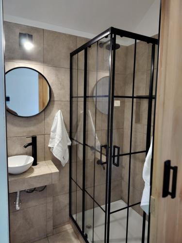 a bathroom with a shower with a sink and a mirror at Refugios de Rio Ilo in Concepción del Uruguay