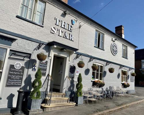 a white building with tables and chairs in front of it at The Star Inn 1744 in Thrussington