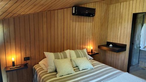 a bedroom with a bed with pillows and a television at Refugios de Rio Ilo in Concepción del Uruguay