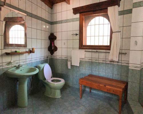a bathroom with a sink and a toilet and a sink at Siesta Riverside Cottages Moshi in Shiri