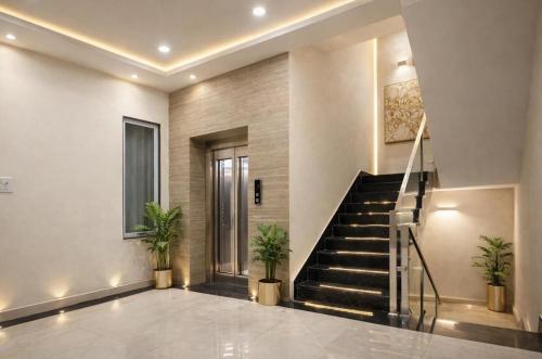 eine Lobby mit Treppe und Topfpflanzen in der Unterkunft Hotel La Opera in Gwalior