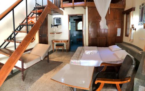 a bedroom with a bed and a spiral staircase at Siesta Riverside Cottages Moshi in Shiri