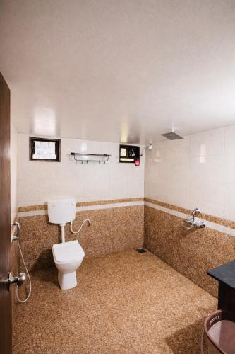 a bathroom with a toilet and a sink at Shwetik Resort in Khamshet