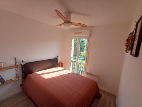 Un dormitorio con una cama y un ventilador de techo. en L'Escapade Basque, en Hasparren