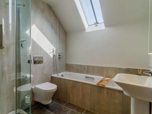 a bathroom with a toilet and a sink and a bath tub at 3 Bed in Saxmundham oc-89691 in Aldringham