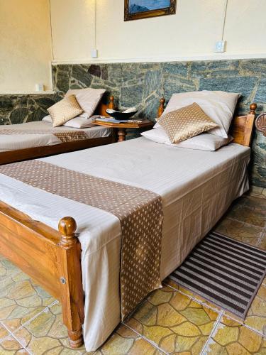 two beds in a hotel room with at The Forest Inn Kandy in Kandy