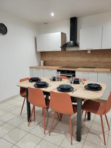 una cocina con una mesa y sillas de madera en L'instant Vosgien, en Laveline-devant-Bruyères