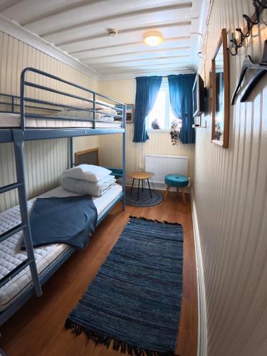 a bedroom with two bunk beds and a rug at Årsunda Strandbad Sjösunda vandrarhem in Årsunda