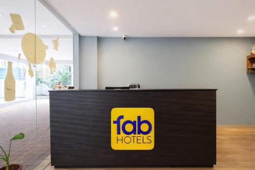a yellow sign on a counter in a room at FabHotel Vedhanshi in Hyderabad