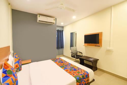 a hotel room with a bed and a television at FabHotel Vedhanshi in Hyderabad