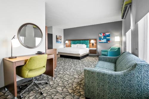 a hotel room with a bed and a desk and a chair at Hampton Inn Bloomington West in Bloomington