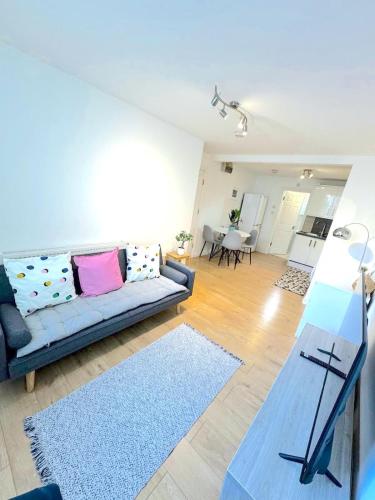 a living room with a couch and a table at Modern 1 BR Apartment close to Emirates Stadium & City Links in London