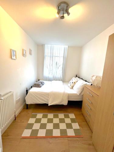 a small bedroom with a bed and a window at Modern 1 BR Apartment close to Emirates Stadium & City Links in London