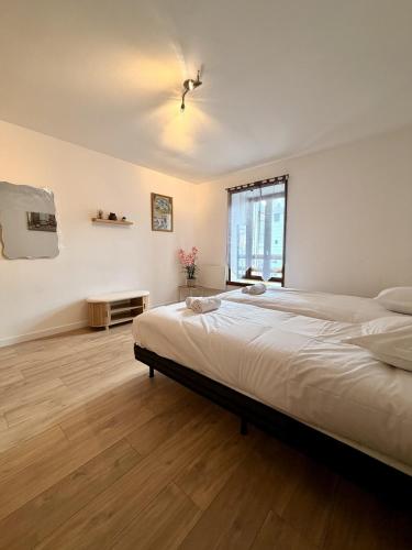a bedroom with a large bed and a window at Le Thylleul - Centre-ville, parking in Albertville