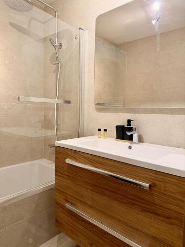 a bathroom with a sink and a shower and a tub at Le Thylleul - Centre-ville, parking in Albertville