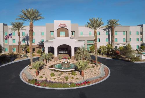 a hotel with a fountain in front of a building at Hampton Inn & Suites Palm Desert in Palm Desert