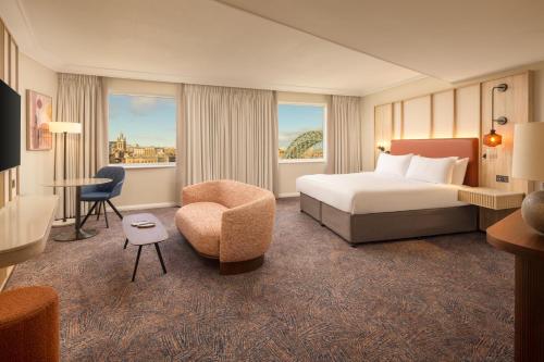 a hotel room with a bed and a chair at Hilton Newcastle Tyne Bridge in Newcastle upon Tyne