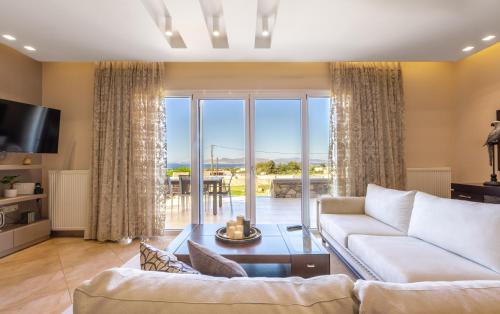 a living room with a couch and a table at Alkis Dream Villa with Jacuzzi in Kos
