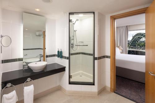 a bathroom with a sink and a glass shower at Hilton Newcastle Tyne Bridge in Newcastle upon Tyne