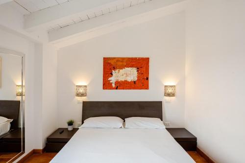 a bedroom with a large white bed with two lamps at Independent house private garden in Milan