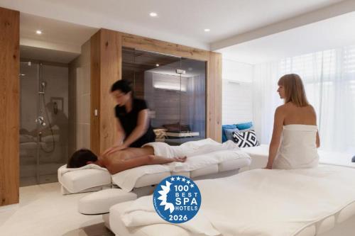 two women standing in a bedroom with beds at Hotel Shuum Boutique - Destigo Hotels in Kołobrzeg