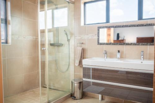 a bathroom with a sink and a shower at Highland Gate Golf & Trout Estate, House 925 in Dullstroom