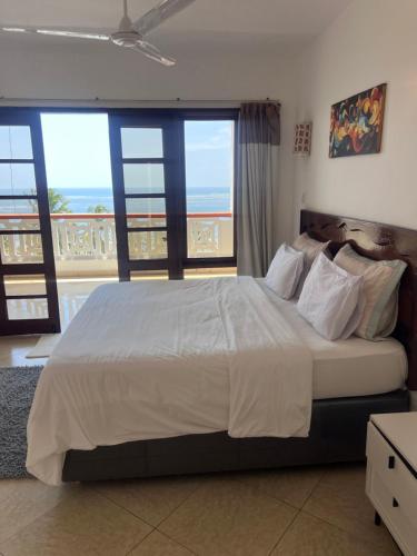 a bedroom with a large bed with a view of the ocean at Ocean Crown Apartments in Mombasa