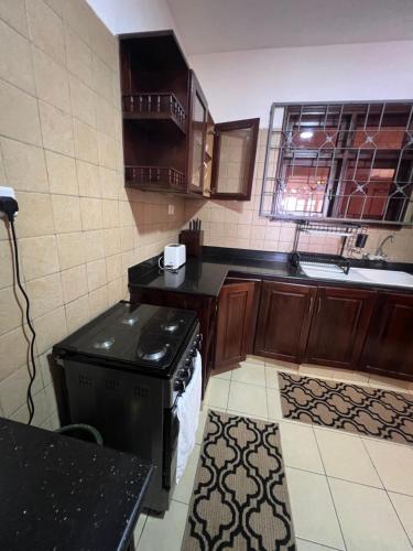 a kitchen with a stove and a sink at Ocean Crown Apartments in Mombasa