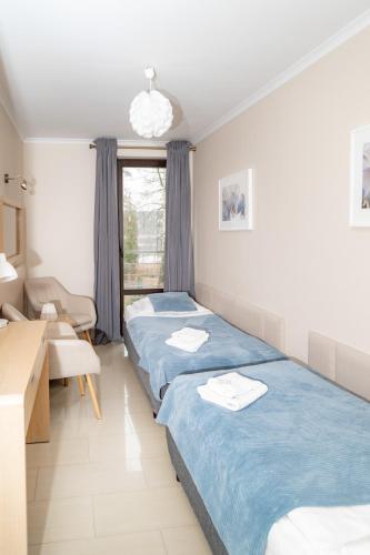 une chambre d'hôtel avec deux lits et une fenêtre dans l'établissement Villa Plena, à Ośno Lubuskie