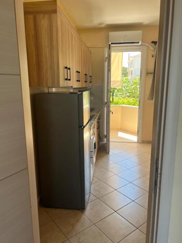 a kitchen with a black refrigerator and a tile floor at Geomelos Theodoros Apartments in Chios