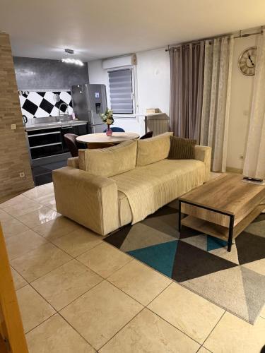 a living room with a couch and a table at Appartement duplex T3 avec box - Paris - La Défense - Airport CDG - Parc des expositions - Stade de France - Disney - Astérix - Val D Europe in Villepinte