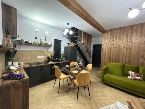 a kitchen and a living room with a green couch at Chalet Alex in Fundata
