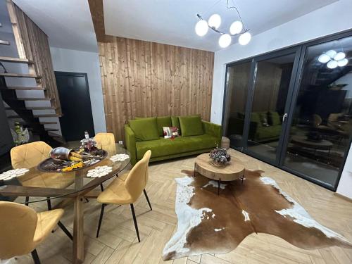 a living room with a green couch and a table at Chalet Alex in Fundata