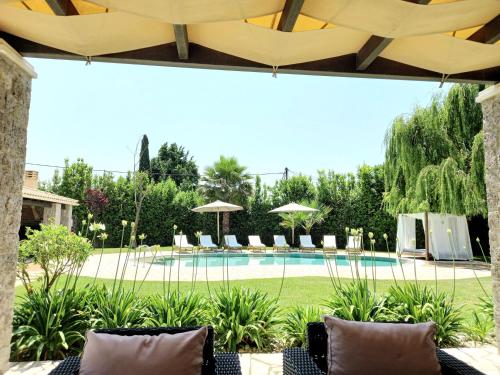 a pool with chairs and umbrellas in a yard at Villa Black White Dassia in Dassia