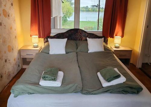 a large bed with two towels on top of it at Gemenc - Lak in Baja