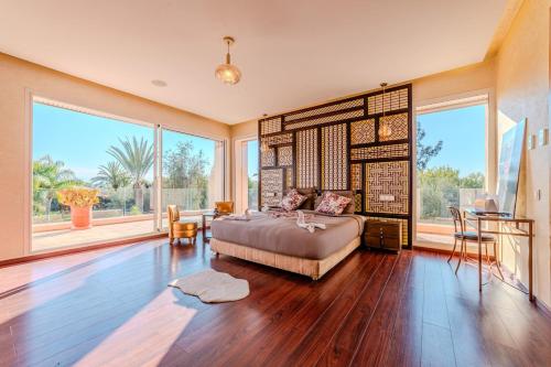 a bedroom with a bed in a room with large windows at Palais Pyar Luxury and Serenity Setting in Najem