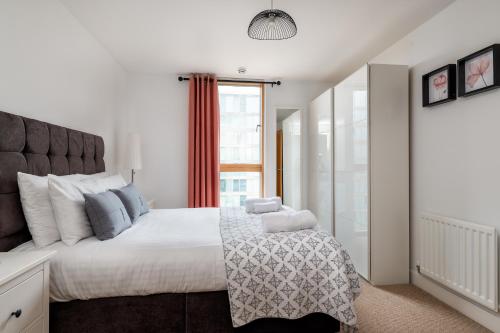 a bedroom with a large bed and a window at City Stay Apartments - Vizion in Milton Keynes
