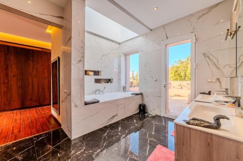 a bathroom with a large tub and a large window at Palais Pyar Luxury and Serenity Setting in Najem
