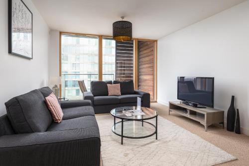 a living room with a couch and a tv at City Stay Apartments - Vizion in Milton Keynes