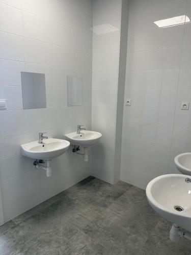 a bathroom with three sinks and a mirror at Mieszkateria in Piotrków Trybunalski