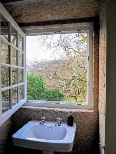 a sink in front of a window with a view at Quinta da Coutada - AgroTurismo in Arcos de Valdevez