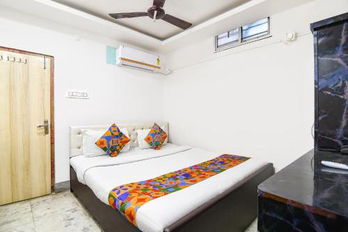 a bedroom with a bed with colorful pillows on it at FabHotel Continental in kolkata