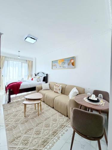 a living room with a couch and a bed at The Kilimani Executive Studio Haven with Gym&Restaurant in Nairobi