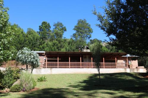 a building in a park with trees in the background at The Stix in Dullstroom