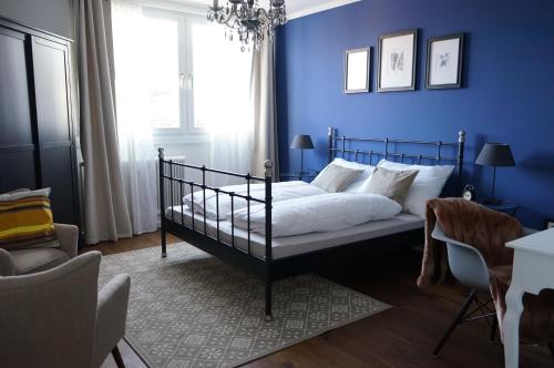 a bedroom with a bed with a blue wall at Stylish New City Appartement in Graz