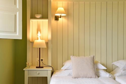 a bedroom with a bed with a lamp and a pillow at Pousada Convento de Evora in Évora