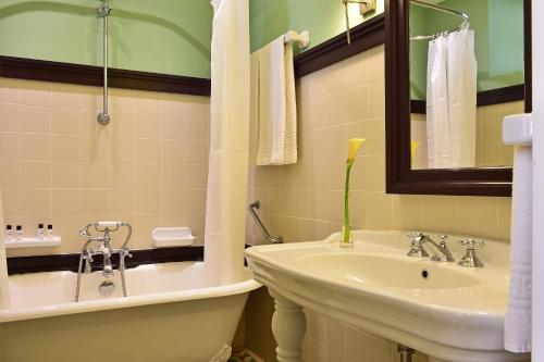a bathroom with a sink and a toilet and a tub at Pousada Convento de Evora in Évora