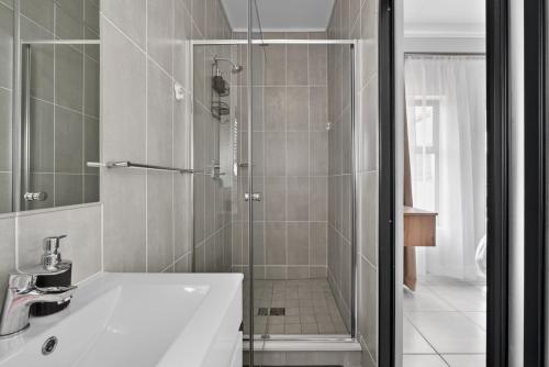 a bathroom with a shower and a white sink at Ballito Hills 830 in Ballito