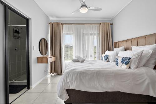 a bedroom with a large white bed and a window at Ballito Hills 830 in Ballito